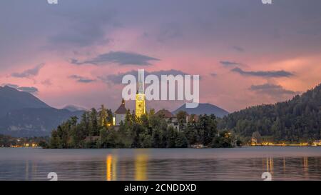 Le lac Bled avec l'église St Mary sur l'île et les montagnes en toile de fond sous le ciel orageux, Slovénie, Europe Banque D'Images