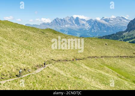 Vélos de montagne et randonneurs sur le sentier de Duron Pass avec le groupe Odle en arrière-plan, Dolomites, Trentin-Haut-Adige, Italie, Europe Banque D'Images