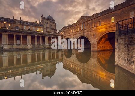 Vue au crépuscule sur le pont unique Pulteney du XVIIIe siècle enjambant la rivière Avon, au cœur de Bath, Somerset, Angleterre, Royaume-Uni Banque D'Images
