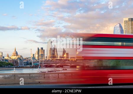 Un bus rouge de Londres passe dans un flou à travers Waterloo Bridge avec la City de Londres et Southbank à distance, Londres, Angleterre, Royaume-Uni, Europe Banque D'Images