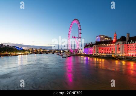 Le London Eye s'allume en rose pendant l'heure bleue, et la Tamise, Londres, Angleterre, Royaume-Uni, Europe Banque D'Images