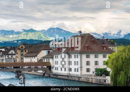 Vieux bâtiments historiques avec pont en bois de Spreuer sur la Reuss et les montagnes en arrière-plan, Lucerne, Suisse, Europe Banque D'Images