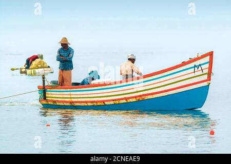 Pêcheurs en bateau coloré sur l'océan arabe juste à côté de la plage populaire de Marari, Mararikulam, Alappuzha (Alleppey), Kerala, Inde, Asie Banque D'Images