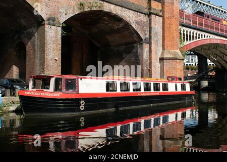 La barge Emmeline Pankhurst amarrée dans le bassin de Castlefield, Manchester, Royaume-Uni, avec un pont de canal en arrière-plan et une réflexion dans l'eau Banque D'Images