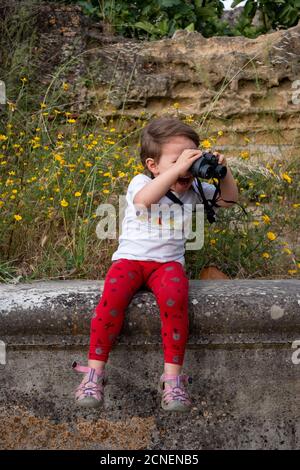 Surprise jeune fille regardant à travers des jumelles. Banque D'Images