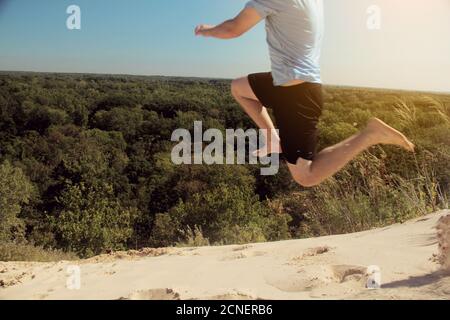 Homme sautant une dune de sable au parc national de Warren Dunes, Michigan Banque D'Images