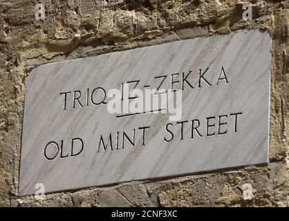 Panneau de rue sculpté pour Old Mint Street, Triq Iz-Zekka sur un mur à la Valette, Malte. Banque D'Images