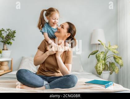 Une belle petite fille et sa mère aiment le soleil matin. Bon séjour à la maison. Banque D'Images