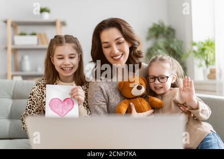 Famille heureuse et aimante. Les jeunes filles et les jeunes mères utilisent un PC tablette pour discuter à distance avec leurs amis. Maman drôle et les enfants adorables ont f Banque D'Images