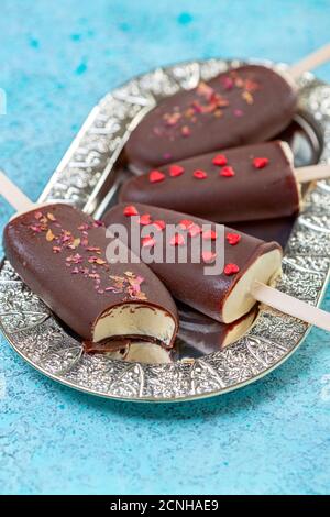 Crème glacée maison sur un bâton avec glaçage au chocolat. Banque D'Images