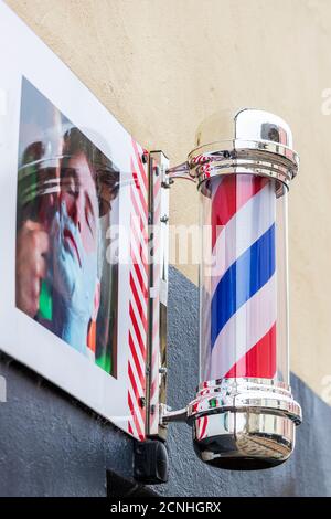 Poteau de barbier traditionnel rouge, blanc et bleu à l'extérieur d'un magasin de coiffeur de gents, Kilwinning, Écosse, Royaume-Uni Banque D'Images