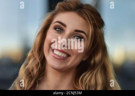 Gros plan portrait d'une belle fille souriante avec de belles dents à l'extérieur dans la rue. Banque D'Images