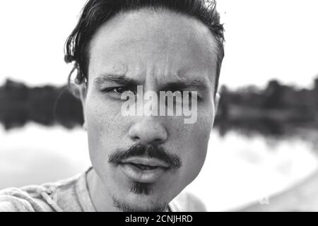 portrait d'un homme brutal et élégant regardant agressivement dans l'appareil photo. photo noir et blanc. photo selfie Banque D'Images