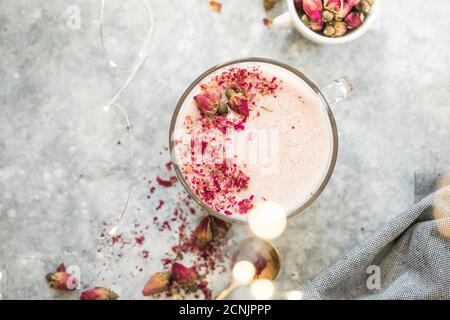 Latte matcha rose avec lait. Boisson tendance. Boisson de Noël. Lait de lune de rose ayurvédique avec un peu de splash dans le verre. Une forme de détente tendance de d Banque D'Images