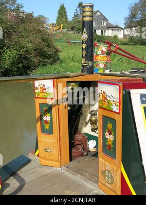 La poupe d'un bateau à narrowboat à la décoration traditionnelle avec les panneaux peints de couleurs vives sur les portes de la cabine qui sont caractéristiques de l'art du canal Banque D'Images