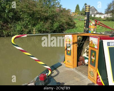 La poupe d'un bateau à narrowboat à la décoration traditionnelle avec les panneaux peints de couleurs vives sur les portes de la cabine qui sont caractéristiques de l'art du canal Banque D'Images