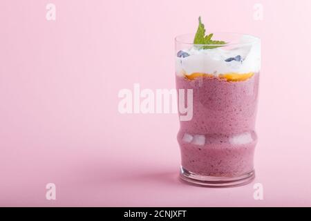 smoothie avec chèvrefeuille, lin et chia dans un verre sur fond rose pastel. vue latérale, gros plan, espace copie. Banque D'Images