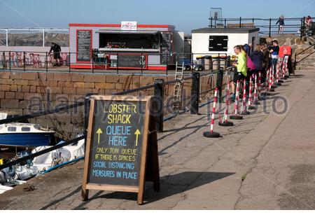 North Berwick, Écosse, Royaume-Uni. 18 septembre 2020. Le temps ensoleillé amène les visiteurs à profiter de la plage et du port de la station balnéaire. Le Lobster Shack vend des fruits de mer au port avec des files d'attente socialement distendus. Crédit : Craig Brown/Alay Live News Banque D'Images