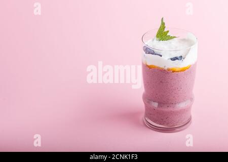 smoothie avec chèvrefeuille, lin et chia dans un verre sur fond rose pastel. vue latérale, gros plan, espace copie. Banque D'Images