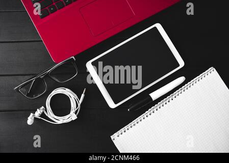 Vue de dessus de l'espace de travail avec livre blanc pour le texte dans le presse-papiers en bois et écran vierge smartphone et ordinateur portable sur tabl en bois Banque D'Images