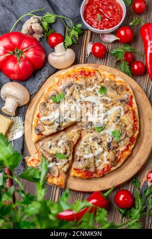 Pizza maison avec tomates, champignons et basilic vert. Banque D'Images