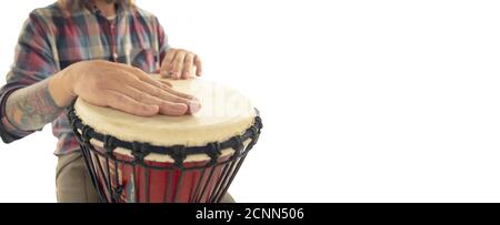 L'homme joue à la percussion ethnique drum darbuka, musicien de gros plan isolé sur fond blanc de studio. Mains mâles tapotant djembe, bongo en rythme. Instruments de musique faits main, son de la culture du monde. Banque D'Images