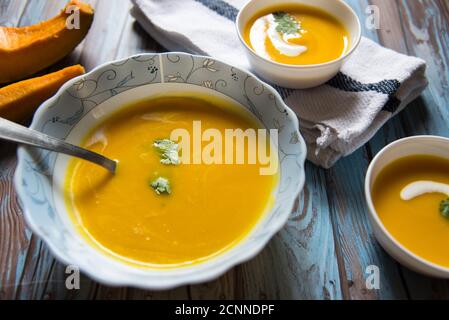 Gros plan d'un bol de soupe de potiron fraîche servi dans deux petits bols. Banque D'Images