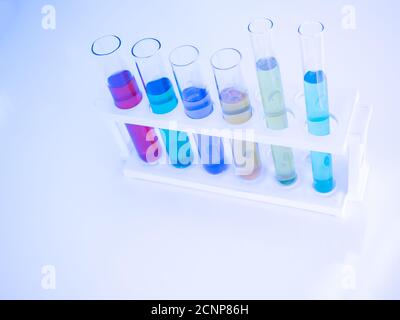 Le tube à essai contient un liquide multicolore. Mettez sur une table pour les expériences scientifiques, les tons de couleur. Banque D'Images
