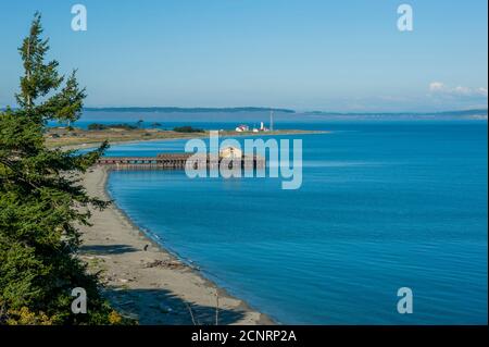 Vue sur la plage et le phare de point Wilson au parc historique de fort Worden à Port Townsend, comté de Jefferson, État de Washington, États-Unis. Banque D'Images