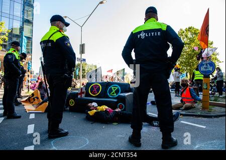 Amsterdam, pays-Bas. 18 septembre 2020. Les policiers ont vu garder un œil sur les activistes pendant la manifestation.Prévisualisation du blocus, les militants du climat se sont rassemblés au Gustav Mahlerplein lors d'une manifestation légale, où les rebelles rouges se sont présentés. Après cela, les activistes ont bloqué la route principale du quartier financier lors d'un acte de désobéissance civile pacifique. Grâce à ces actions, XR exige une Assemblée des citoyens pour une politique climatique équitable. Après quelques heures, plusieurs d'entre eux ont été arrêtés par la police néerlandaise. Crédit : SOPA Images Limited/Alamy Live News Banque D'Images