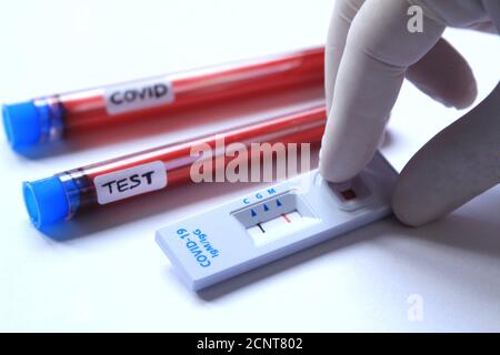 Travailleur médical plaçant l'échantillon de sang sur le test de diagnostic rapide identification Anticorps contre le coronavirus SRAS-COV-2 COVID-19 Banque D'Images