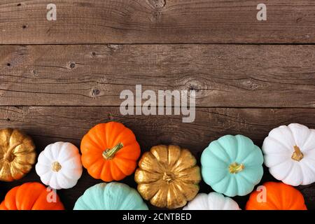 Bordure inférieure d'automne de plusieurs citrouilles colorées sur un fond de bois rustique. Vue de dessus avec espace de copie. Banque D'Images