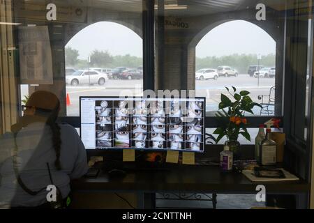 Rio Bravo, Texas USA 17 septembre 2020: Un agent de sécurité observe l'entrée principale de l'école moyenne Salvador Garcia à Colonia's Rio Bravo près de Laredo, le long de la frontière texane avec le Mexique, lors d'une rare averse. L'école du district Uni, se prépare à des cours en personne la semaine prochaine. Banque D'Images