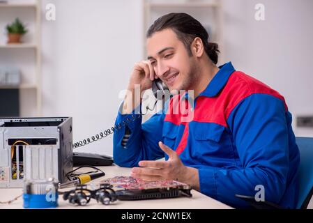 Jeune homme réparateur réparant un ordinateur PC Banque D'Images