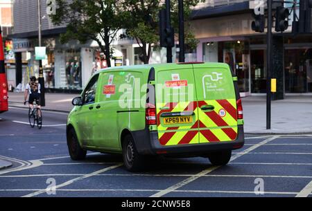 18 septembre 2020. Livraison de véhicule électrique zéro émission Royal Mail en minibus traversant une boîte de jonction dans Oxford Street, dans le centre de Londres, derrière un cycliste avec Debenhams magasin en arrière-plan. Banque D'Images