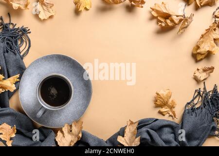 Cadre avec café d'automne, écharpe chaude et feuilles de chêne sec sur beige. Arrière-plan de chute. Jour de Thanksgiving. Espace pour le texte. Vue de dessus. Banque D'Images
