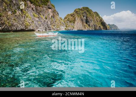 El Nido, Palawan, Philippines. Bateau Banca dans l'eau cristalline de l'océan près de l'île de Matinloc, les points forts de l'excursion à la Tour C. Banque D'Images