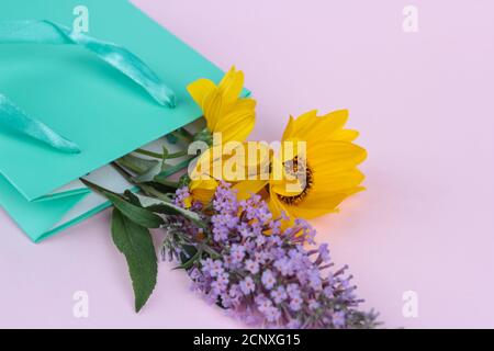 fleurs sauvages, jaune et lilas dans un sac cadeau, concept de salutation, cadeau. espace pour le texte Banque D'Images