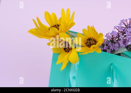 fleurs sauvages, jaune et lilas dans un sac cadeau, concept de salutation, cadeau. espace pour le texte Banque D'Images