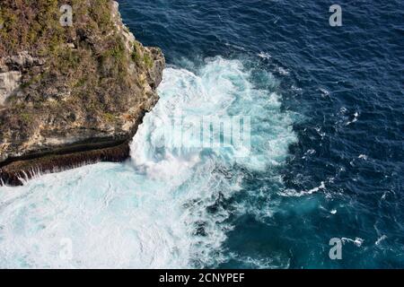 Vue spectaculaire sur les vagues de l'océan s'écrasant autour des rochers sur l'île de Nusa Penida, Bali, Indonésie Banque D'Images