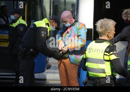 Un agent anti-émeute de la police néerlandaise arrête un activiste des rébellions en voie d'extinction pendant Les manifestants bloquent la rue dans le quartier financier de Zuidas Le Coro Banque D'Images