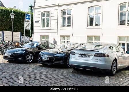 Copenhague, Danemark - 27 août 2019 : trois voitures électriques Tesla modèle S garées dans une rue avec des gens autour de Copenhague, Danemark Banque D'Images