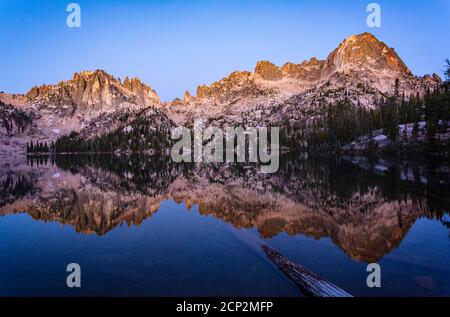Baron Peak se reflète à Baron Lake pendant l'heure bleue avant le lever du soleil, Sawtooth Wilderness, Idaho, États-Unis. Banque D'Images