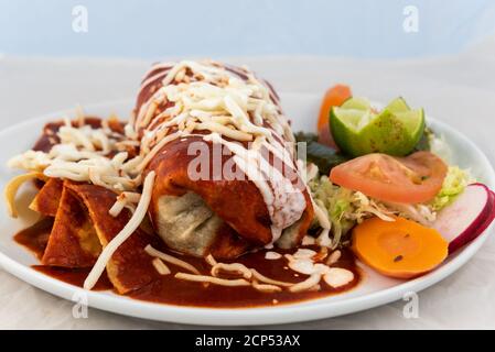 Mouillez le burrito de ranchero avec du riz et des haricots servis sur une plaque chaude pour quelques délicieux plats mexicains. Banque D'Images