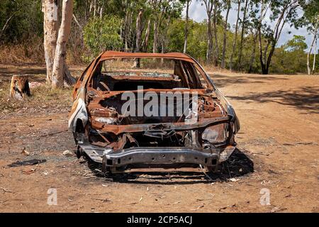 L'épave roulante d'une voiture brûlée laissée abandonnée brousse avec la plupart de ses pièces volées Banque D'Images