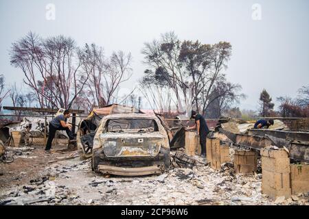 TALENT, ORE - 18 SEPTEMBRE 2020 : Teresa de la Cruz, Juan Gonzalez et Daisy Gonzalez ont mené une enquête sur les dégâts de leur maison à l'intérieur de Talent Mobile Estates #81 dans le cadre des suites de l'incendie d'Almeda. La ville de Talent, Oregon, montrant les maisons brûlées, les voitures et les gravats laissés derrière. Dans Talent, à environ 20 miles au nord de la frontière de la Californie, les maisons ont été charrées au-delà de la reconnaissance. Dans l'ouest des États-Unis, au moins 87 feux de forêt sont en feu, selon le National Interagency Fire Center. Ils ont torqué plus de 4.7 millions d'acres -- plus de six fois la région de Rhode Island. Crédit : Chris Tuite/ima Banque D'Images