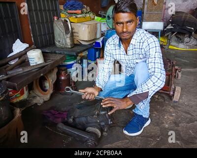 DISTRICT KATNI, INDE - 09 DÉCEMBRE 2019 : un mécanicien indien réparant un moteur à partir d'un tournevis à l'atelier automobile. Banque D'Images