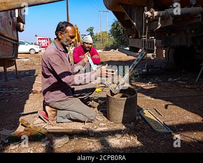 DISTRICT KATNI, INDE - 09 DÉCEMBRE 2019 : un mécanicien automobile indien moulant une pince pour camion de fer à l'atelier en zone ouverte. Banque D'Images