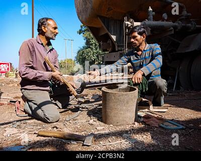 DISTRICT KATNI, INDE - 09 DÉCEMBRE 2019 : deux mécaniciens automobiles indiens travaillent ensemble à l'atelier en zone ouverte. Banque D'Images