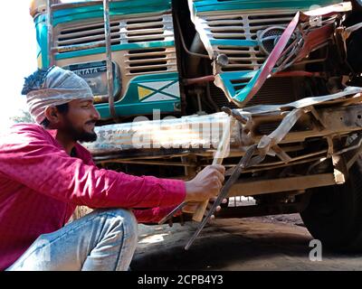 DISTRICT KATNI, INDE - 09 DÉCEMBRE 2019 : un mécanicien de village asiatique répare la carrosserie accidentelle d'un camion dans un garage à aire ouverte. Banque D'Images